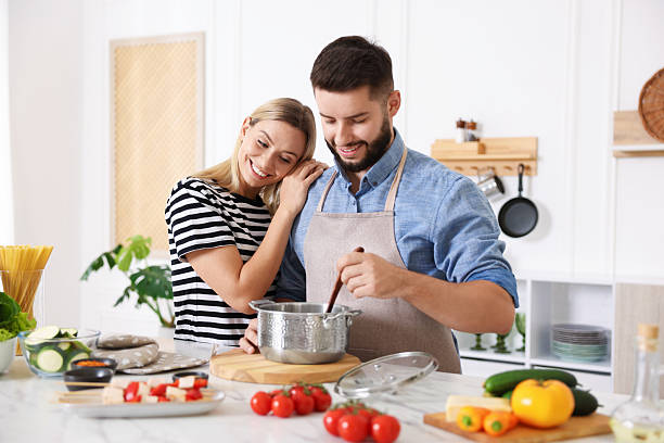 istock Happy couple cooking together at table in kitchen 2247833641