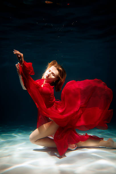 istock Enigmatic ritual performed by dancer submerged in scarlet water 2247833775