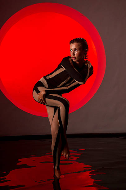 istock A slender, athletic woman poses in a studio against a red backdrop. 2247836075