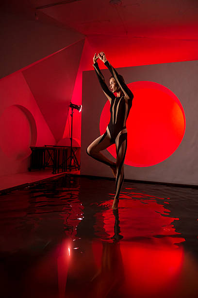istock A slender, athletic woman poses in a studio against a red backdrop. 2247836506