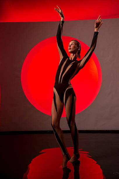 istock A slender, athletic woman poses in a studio against a red backdrop. 2247837392
