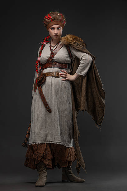 Fantasy Scandinavian heroine with battle axe, wearing fur cape on neutral gray.