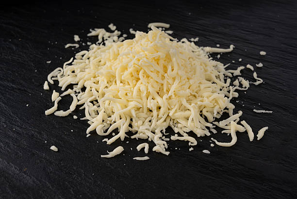 istock Grated mozzarella cheese on black background. Shredded mozarella texture 2247841497
