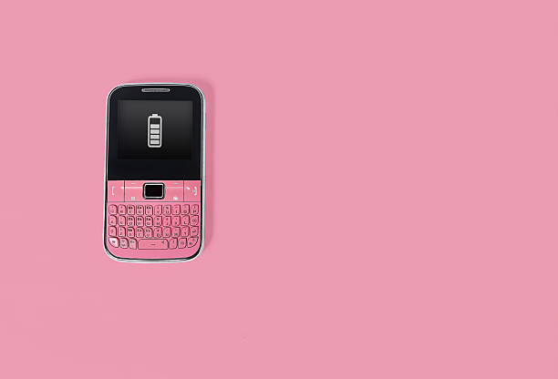 A vintage pink cell phone on a pink background.