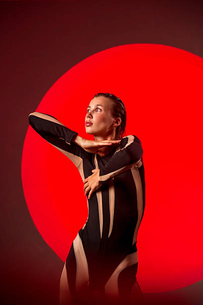 istock A slender, athletic woman poses in a studio against a red backdrop. 2247843718