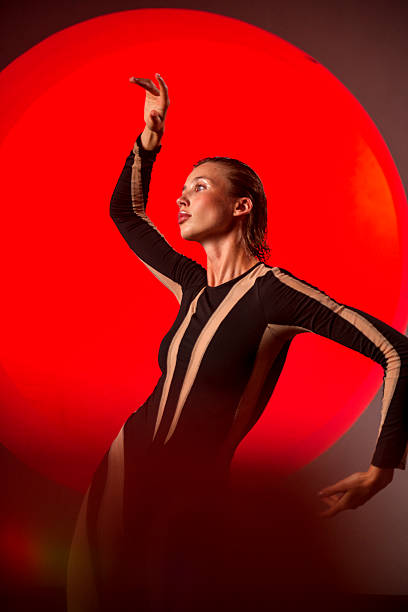 istock A slender, athletic woman poses in a studio against a red backdrop. 2247843805