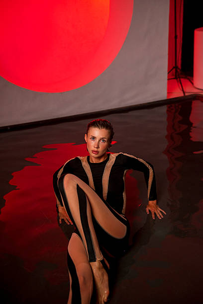istock A slender, athletic woman poses in a studio against a red backdrop. 2247843865