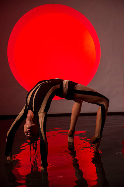 istock A slender, athletic woman poses in a studio against a red backdrop. 2247843978
