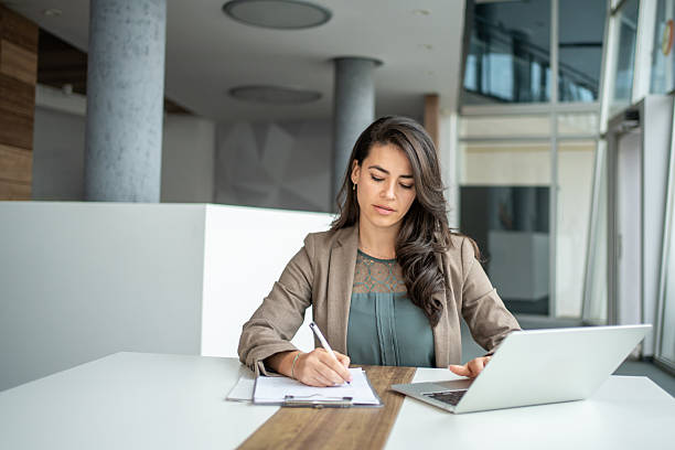 istock Professional businesswoman writing notes working at office desk 2247848440