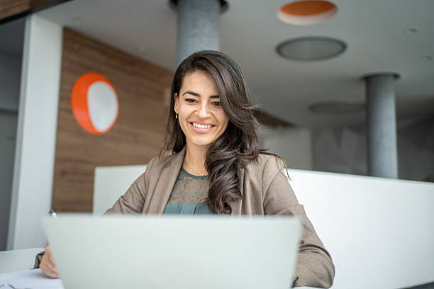 istock Businesswoman smiling working on laptop in modern office 2247848459