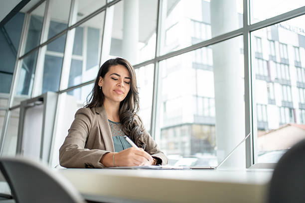 istock Woman writing notes working on laptop in modern office 2247848506