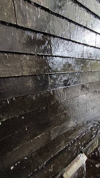 istock Close up background of black stone wall decorated with artificial waterfall 2247848889