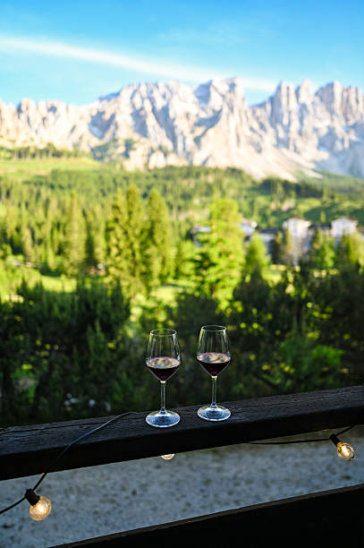 istock Red wine glasses on balcony overlooking dolomite mountains 2247850113