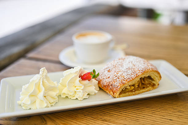 Horizontal view of one the most famous austrian cakes - Apfelstrudel - with whipped creme.