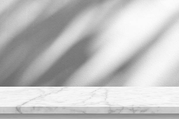 istock Marble table with tree shadow drop on white wall background for mockup product display 2247851494