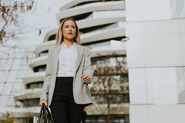 istock Business professional walking confidently outside modern architecture during daytime 2247856684