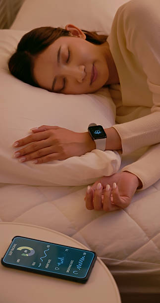 istock Woman sleeping with smartwatch and smartphone tracking sleep data 2247861401