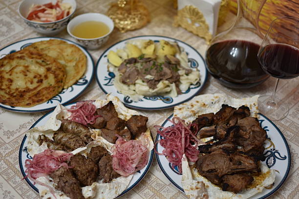 istock Assorted grilled meats including lamb, chicken, and lyulya-kebab, beshbarmak, and red wine in glass decanter 2247862317