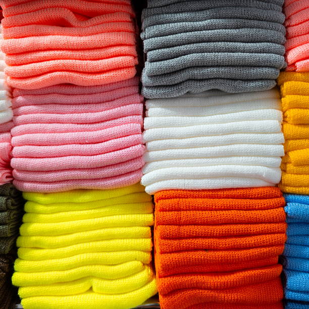 istock Colorful stacked sweaters arranged neatly in a display showcasing various shades at a clothing store on a sunny afternoon 2247863845