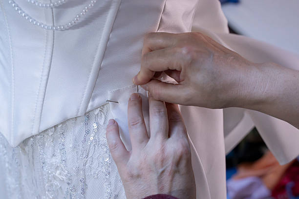 istock The seamstress's hand sewing beads on a wedding dress 2247876734
