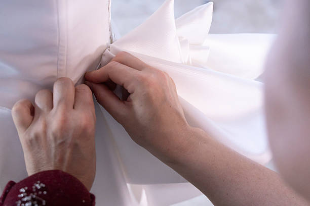 istock The seamstress's hand sewing beads on a wedding dress 2247876868