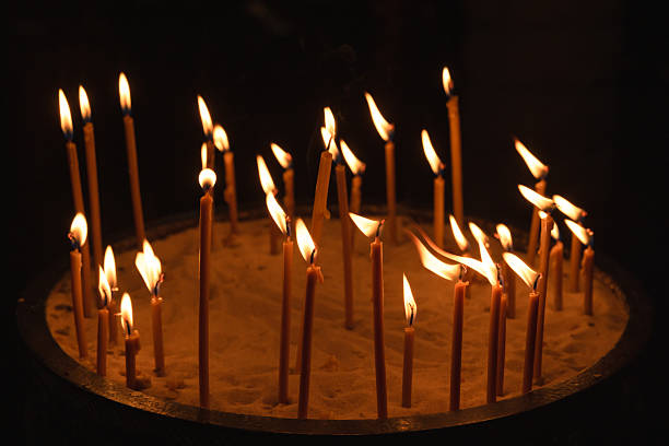 istock Sacred church scene featuring a round sand tray, several lit prayer candles 2247881283