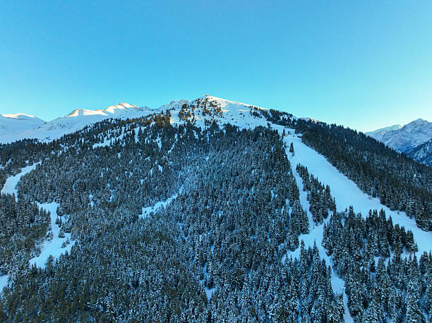 istock Snow-covered mountain slope with ski runs and clear blue sky 2247882487