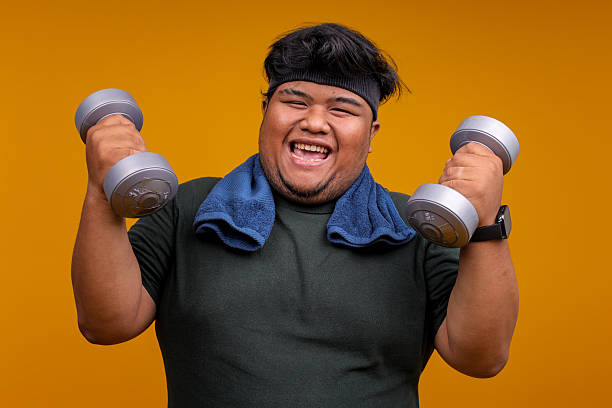 istock Joyful Asian Fat Man Laughing While Lifting Dumbbells in Fitness Workout Routine 2247883999