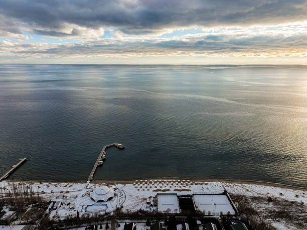 istock Snowy beach and pier on large inland lake 2247884383