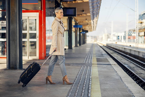 istock Woman traveling on train station platform with luggage 2247884529