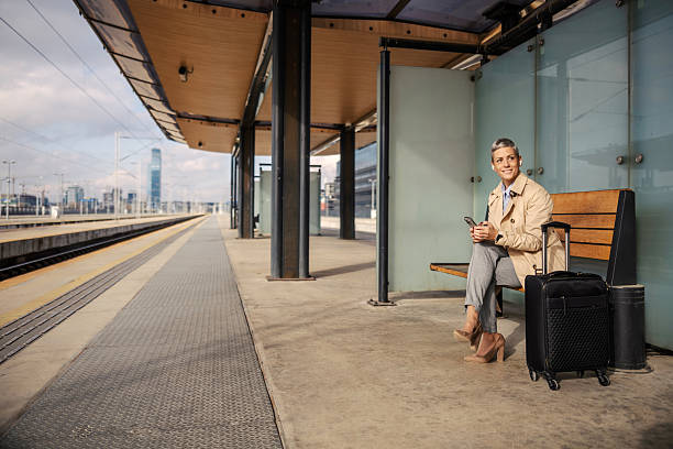 istock Woman waiting for train using smartphone at station 2247884662