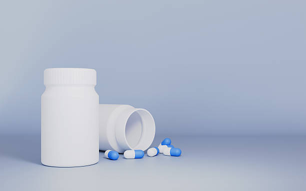 istock Blue and white capsules pill spilled out from white plastic bottle 2247885009