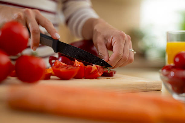 istock Woman cutting fresh tomatoes on a chopping board 2247891066