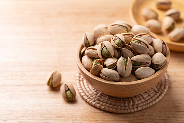 istock Roasted Pistachio nuts in a bowl on wooden background 2247891475