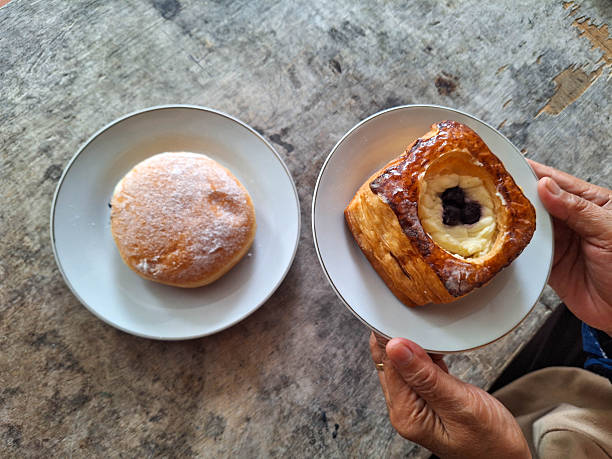 Woman Preparing Danish Blueberry Cheese Puff Pastry and Blueberry Jam Filled Doughnuts Donut for lunch.