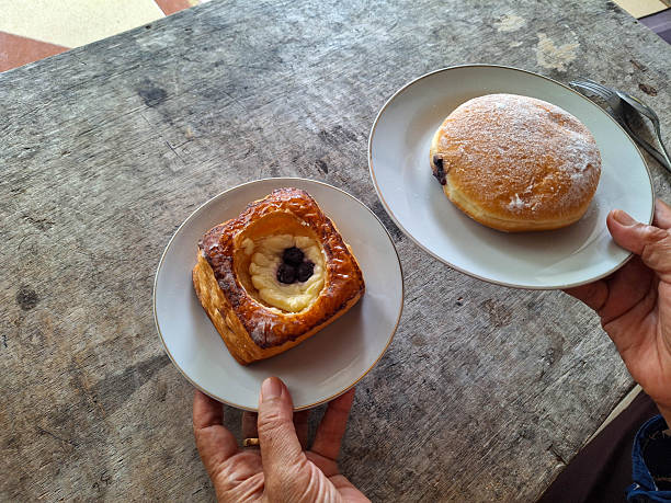 Woman Preparing Danish Blueberry Cheese Puff Pastry and Blueberry Jam Filled Doughnuts Donut for lunch.