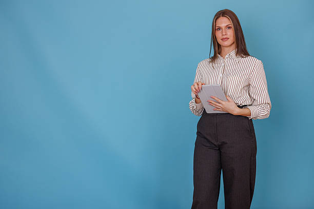 istock Professional young businesswoman standing with tablet showing confidence on blue studio background 2247894582