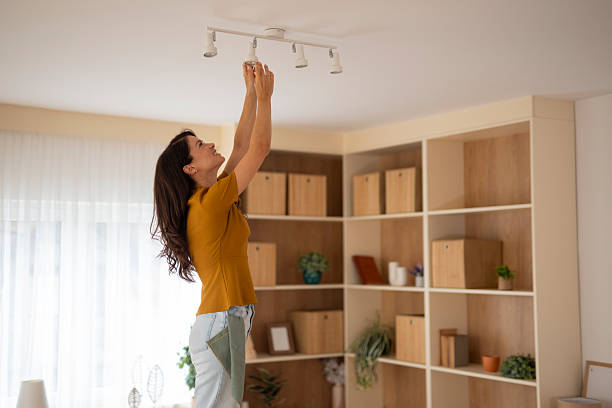 istock Woman changing lightbulb in home doing maintenance 2247895760