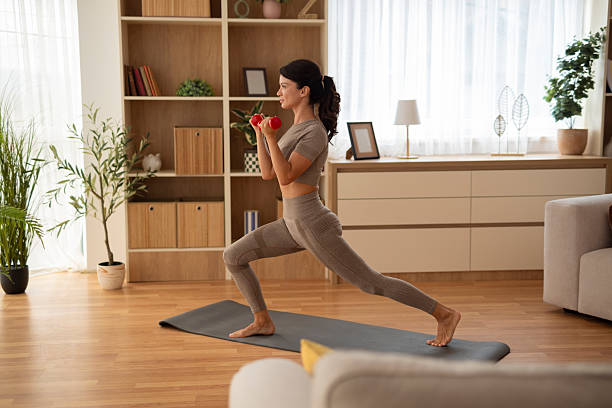 istock Woman exercising at home doing dumbbell lunge workouts 2247897563
