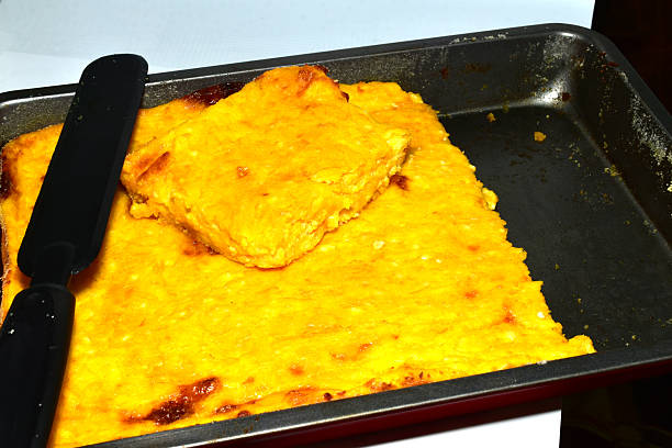 A casserole made from cottage cheese and pumpkin lies in a baking sheet. View from above.