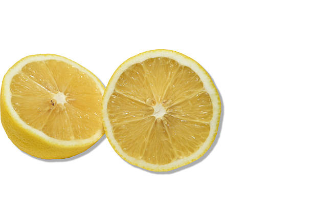 Two halves of a cut lemon lie on a white background.