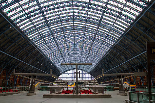 London, England - September 10, 2012: Trains wait at the platforms of London's St. Pancras International Station, framed by the station's vast arched glass roof.