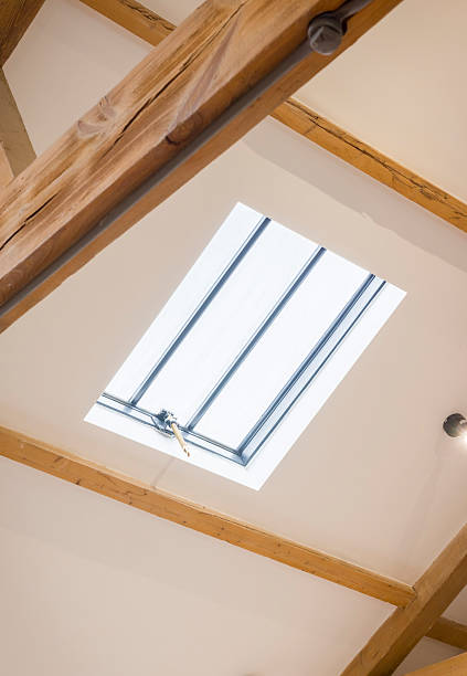 istock Skylight window in white sloped ceiling with oak beams, UK loft 2247904737