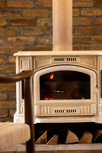 istock Brick fireplace with a wood burning stove and two chairs. 2247905134