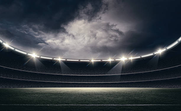 istock Dramatic Night at Stadium with Illuminated Football Field and Stormy Sky, 3d rendering 2247906733