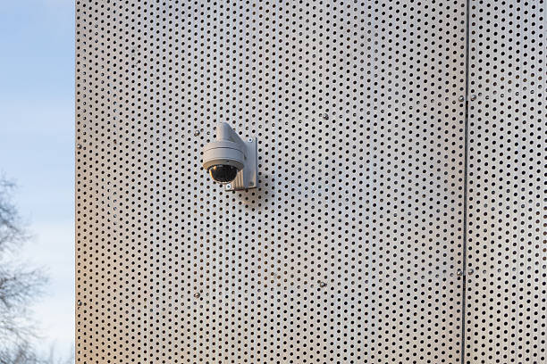 A surveillance security camera installed on the exterior wall of a building, used for monitoring and safety in an urban environment