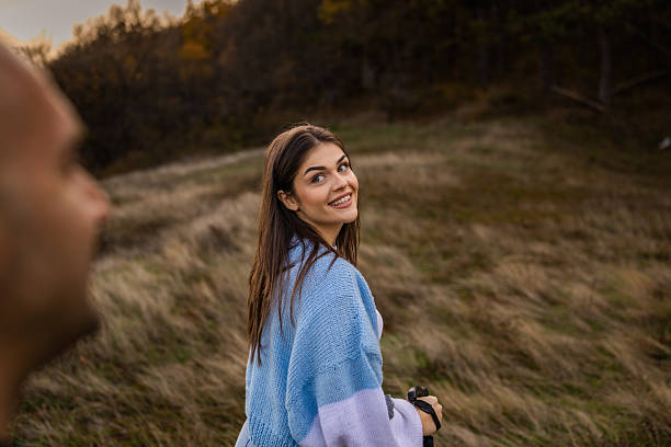 Friends exploring forest in the autumn day. Girl in the focus. Friendship and healthy lifestyle concept.