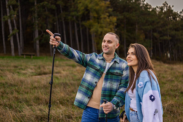 istock Handsome man pointing with finger far away in the forest while hiking with her friend. 2247914991