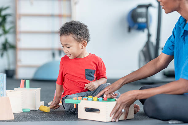 istock Young Black Boy Plays With Educational Toys While Caregiver Guides Learning and Playtime 2247916257