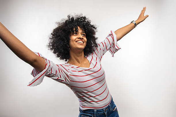 istock Young Asian Woman Joyfully Stretching Arms in Studio Setting 2247917791